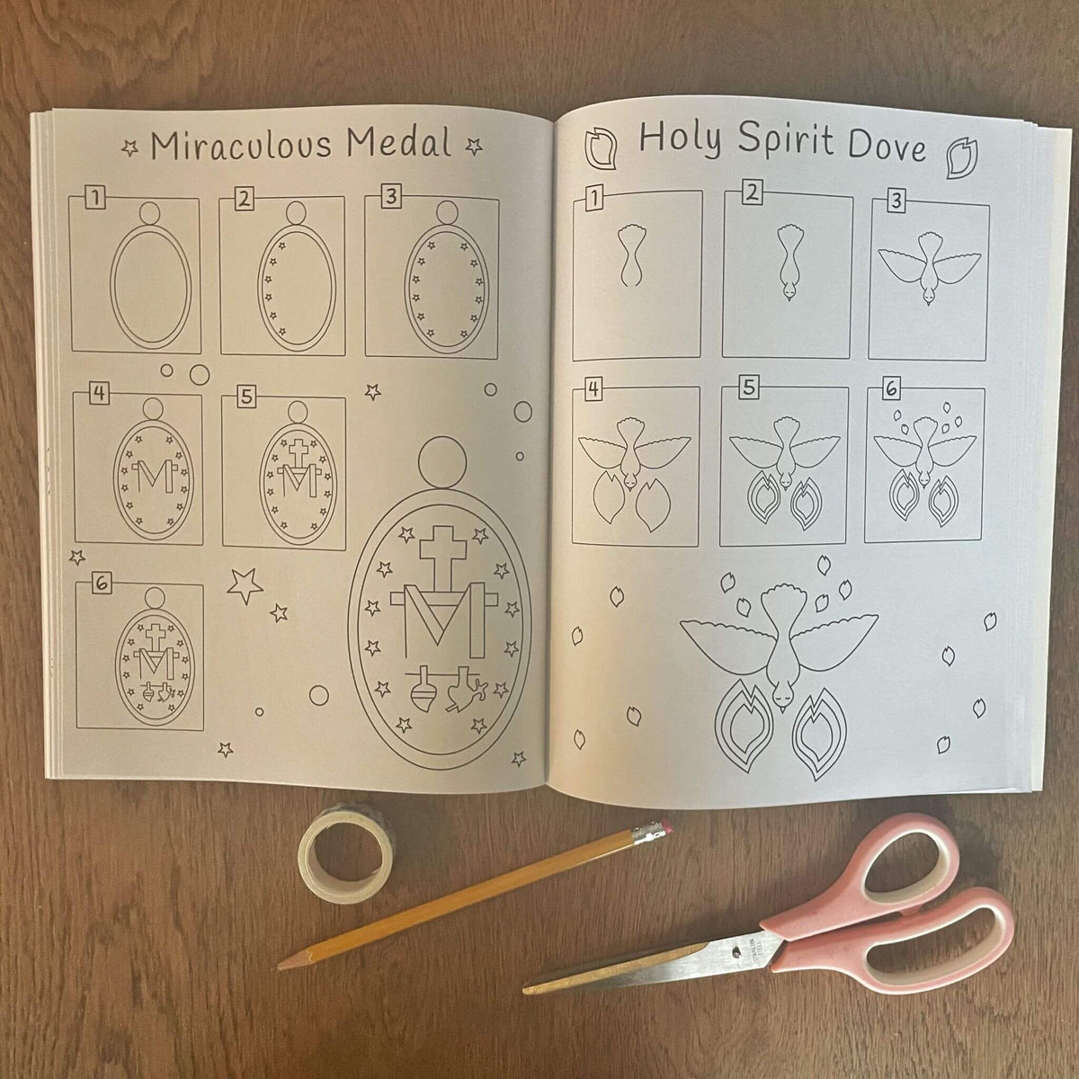 Open Catholic 2-in-1 Art Book featuring Miraculous Medal and Holy Spirit Dove drawings for coloring and drawing, with scissors and pencil.