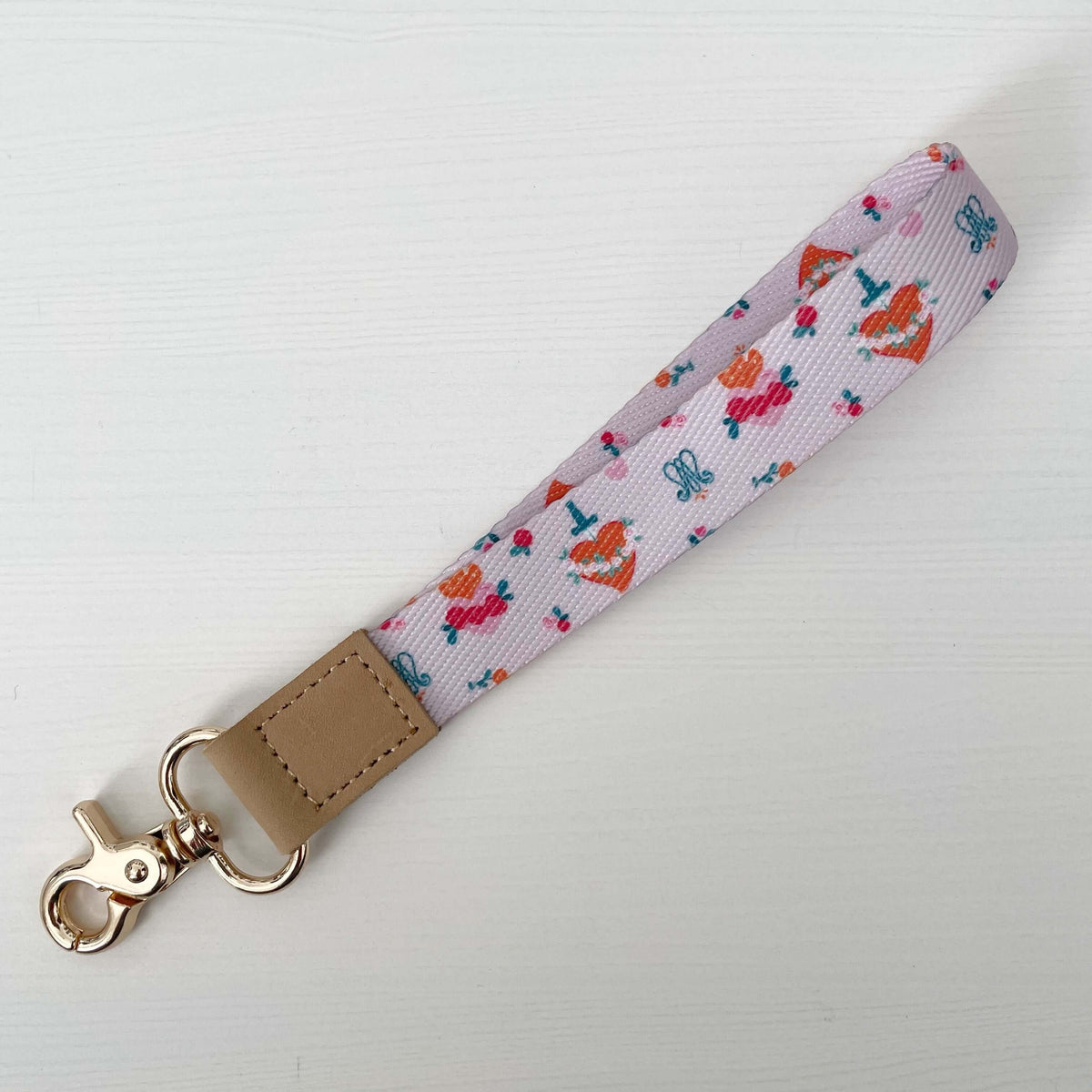 Catholic Wrist Lanyard from the Auspice Maria Collection featuring soft pink and floral patterns with a metal clasp.