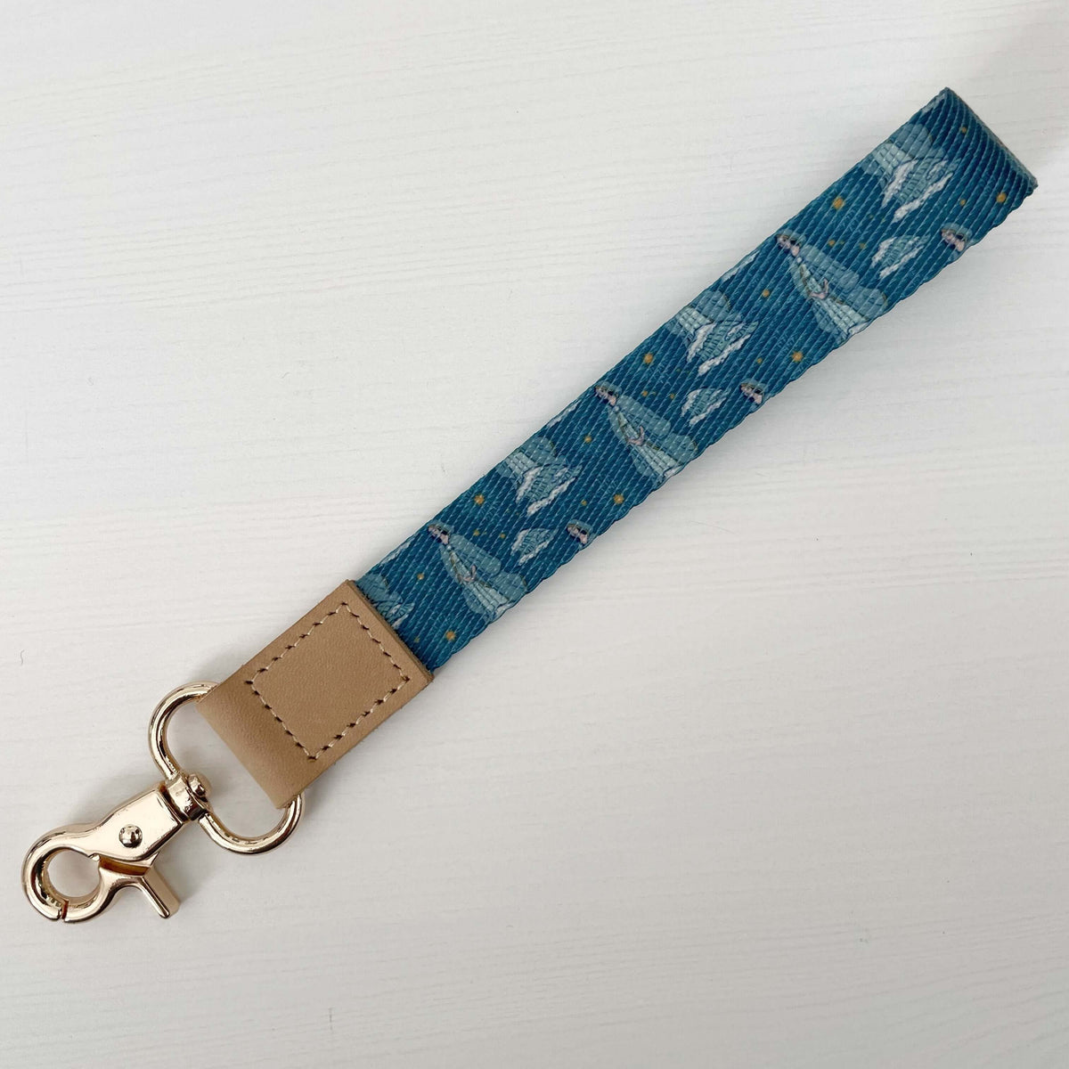 Blue Stella Maris Catholic wrist lanyard with seashell pattern, featuring brown leather clip, perfect for faith and function.