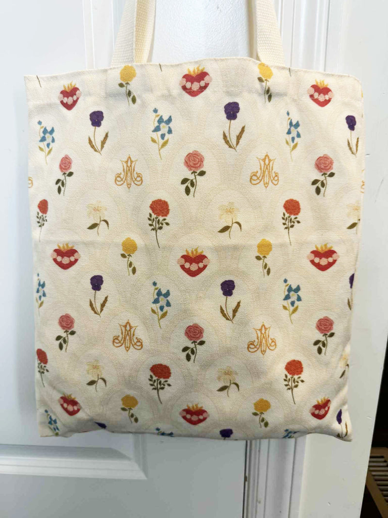 Floral Catholic-inspired tote bag with Sacred Heart and Mary's symbols, featuring a vibrant floral pattern.