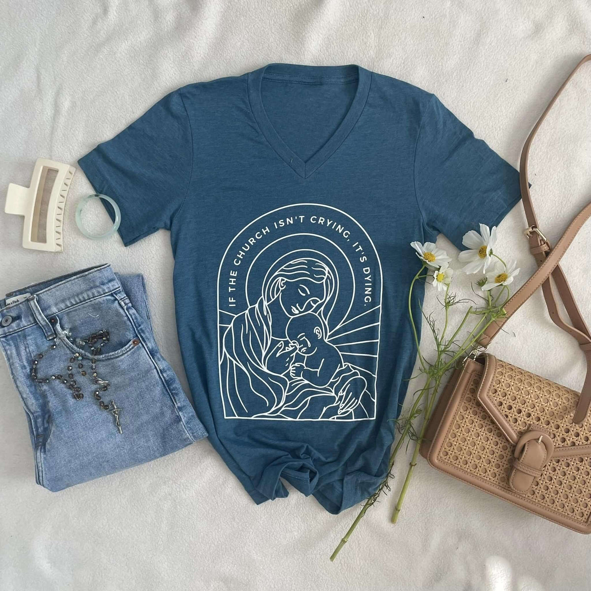Heather deep teal V-neck tee with 'If The Church Isn't Crying, It's Dying' screen print, paired with jeans and accessories.