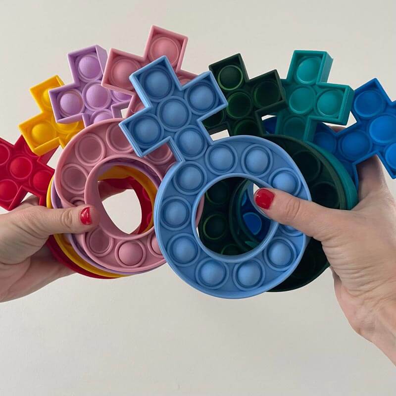 Colorful silicone fidget rosary poppers in various shapes and colors held in hands, used for stress relief and focus.