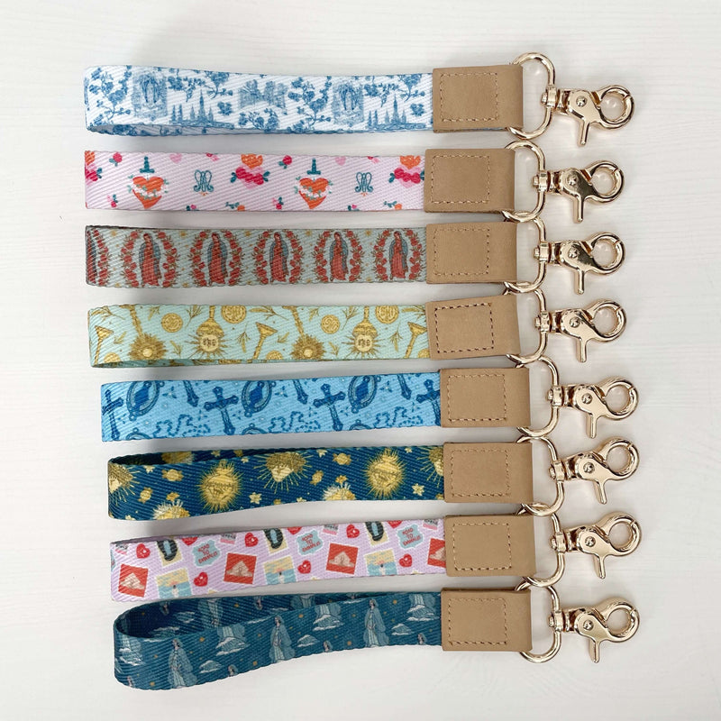 Assorted Catholic wrist lanyards from Lourdes Collection with various religious patterns and colors, showcasing faith and style.