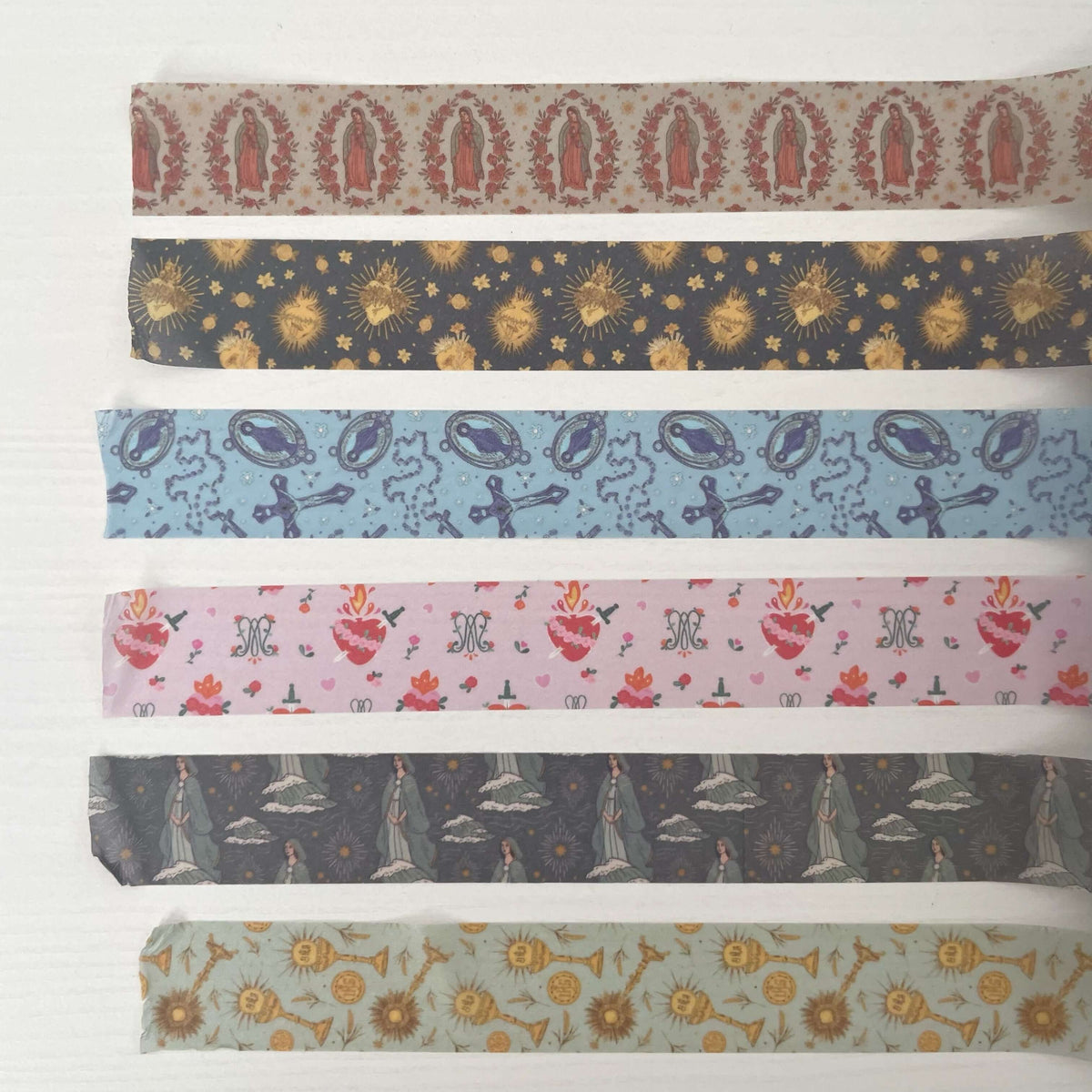 Alt Tag: "Catholic Washi Tape Set featuring designs of Guadalupe, Stella, Rosary, Holy Hearts, Auspice Maria, and Eucharistic motifs."