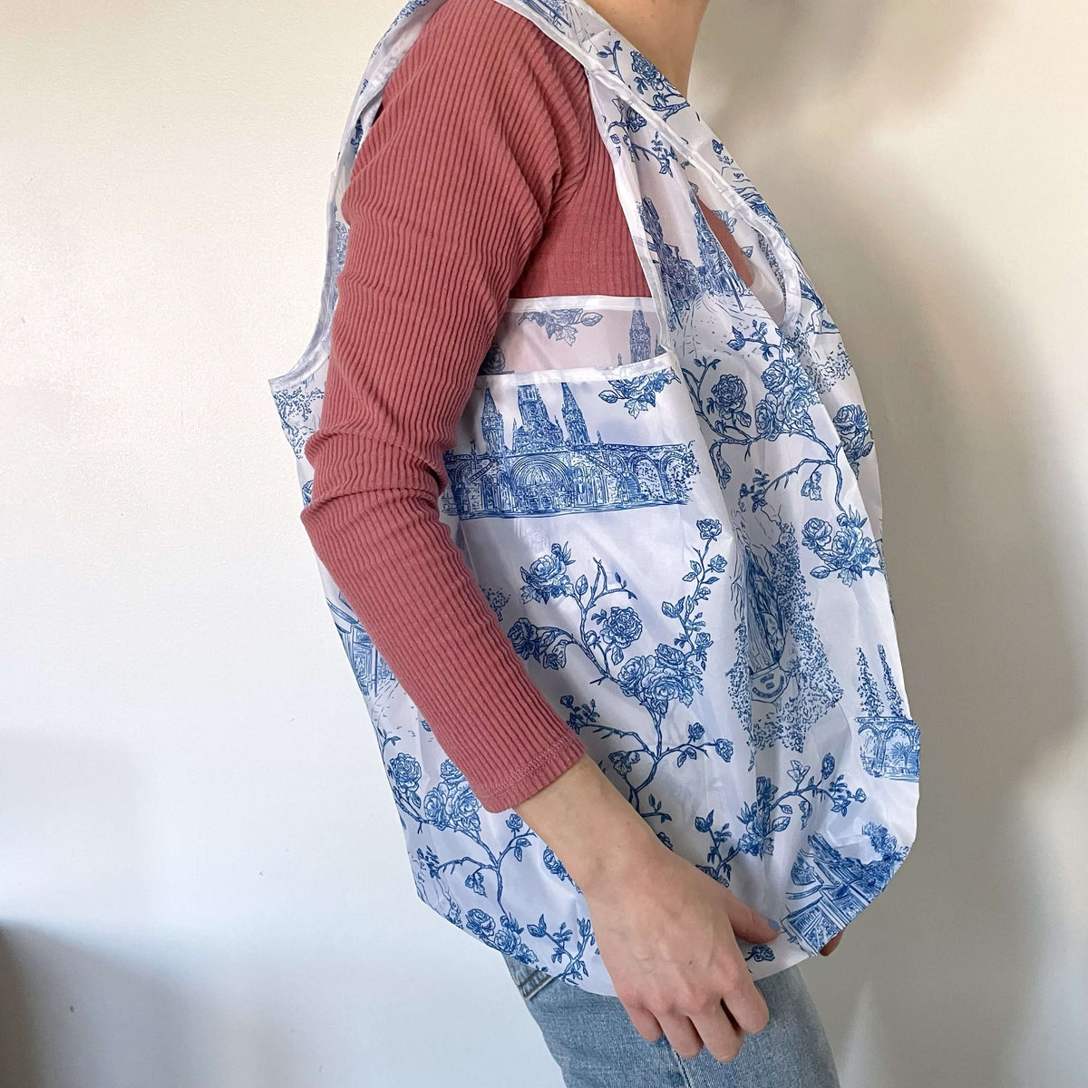 Person carrying Catholic Reusable Grocery Bag with blue Lourdes pattern, made of sturdy 190T polyester.