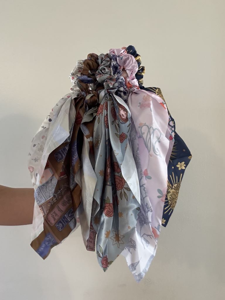 Assorted Catholic satin scrunchies with elegant patterns and ribbons, perfect for a feminine touch and faith-inspired style.