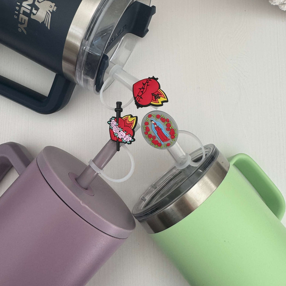 Catholic straw toppers set featuring Sacred Heart, Immaculate Heart, and Our Lady of Guadalupe designs on colorful mugs.