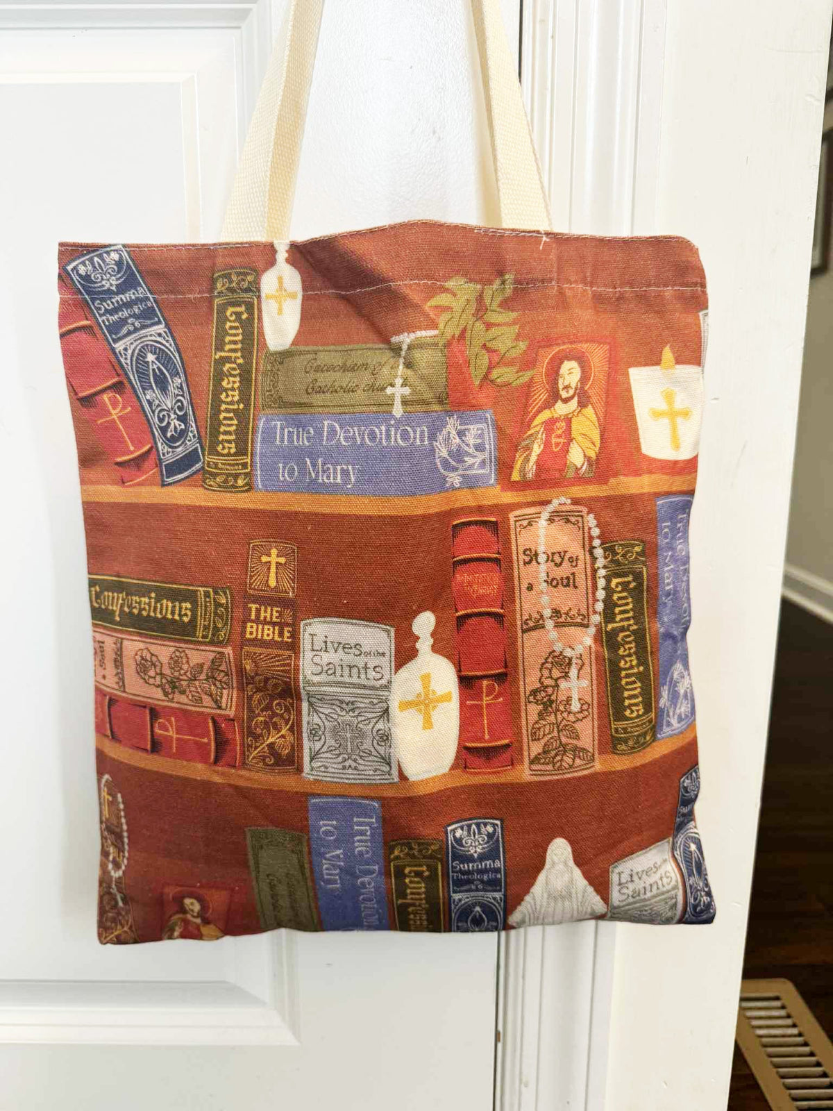 Catholic Library Tote Bag with religious book design, perfect for carrying essentials and displaying faith.