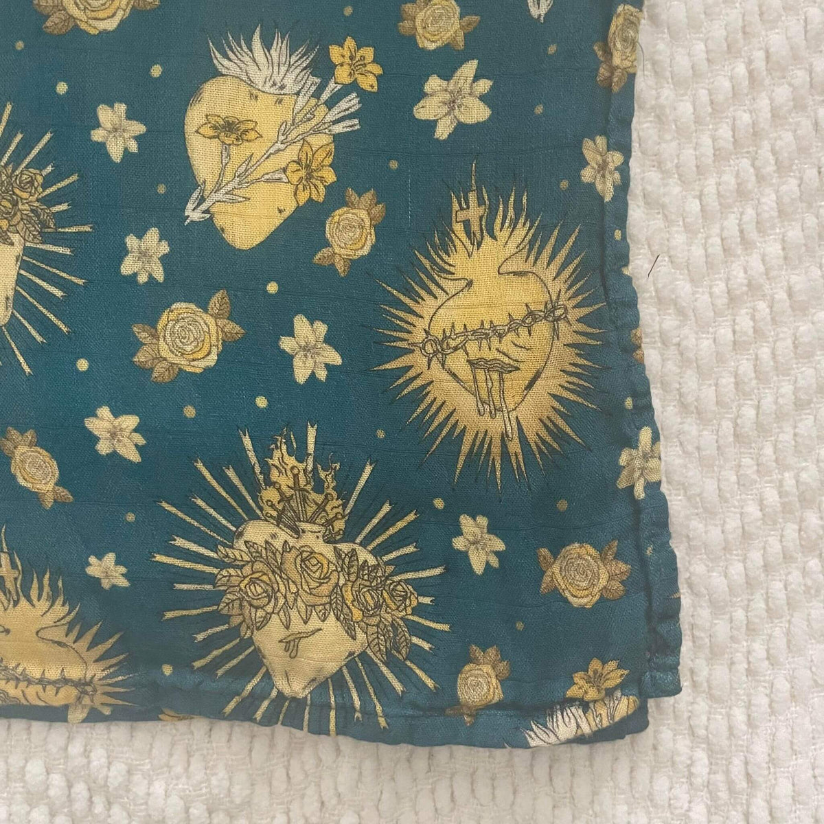 Holy Hearts swaddle blanket with Catholic symbols on organic bamboo cotton, featuring sacred heart designs for babies.