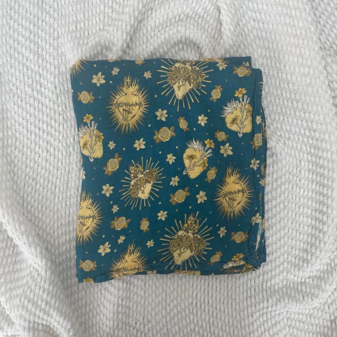 Holy Hearts swaddle blanket featuring Catholic sacred heart design, 100% organic bamboo cotton, 47x47 inches for baby comfort.