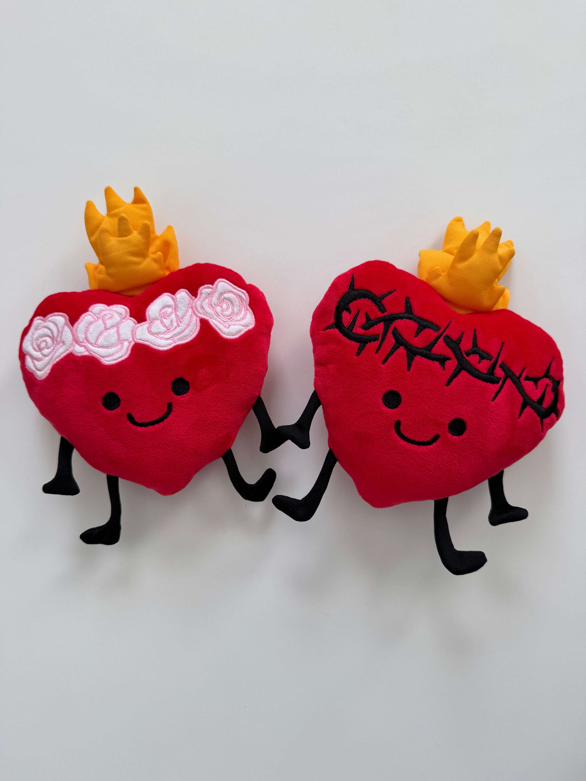 Sacred Heart and Immaculate Heart plush toys with smiling faces and gentle flames, symbolizing love and comfort for kids and prayer spaces.