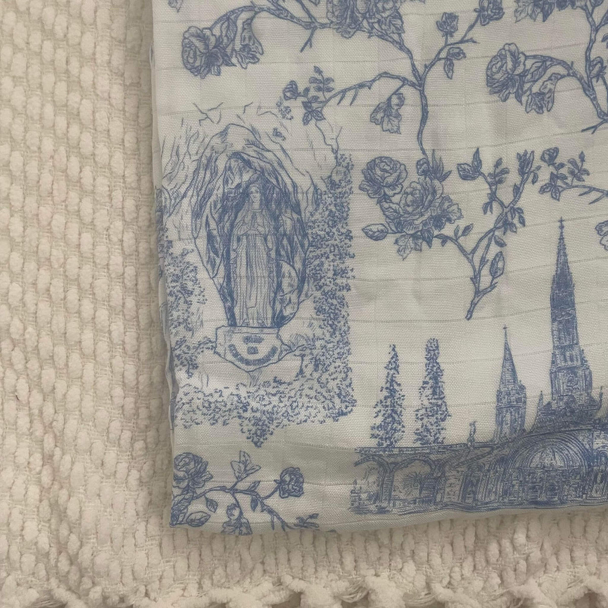 Lourdes swaddle blanket with blue religious and floral patterns on organic bamboo cotton, 47x47 inches, for babies.