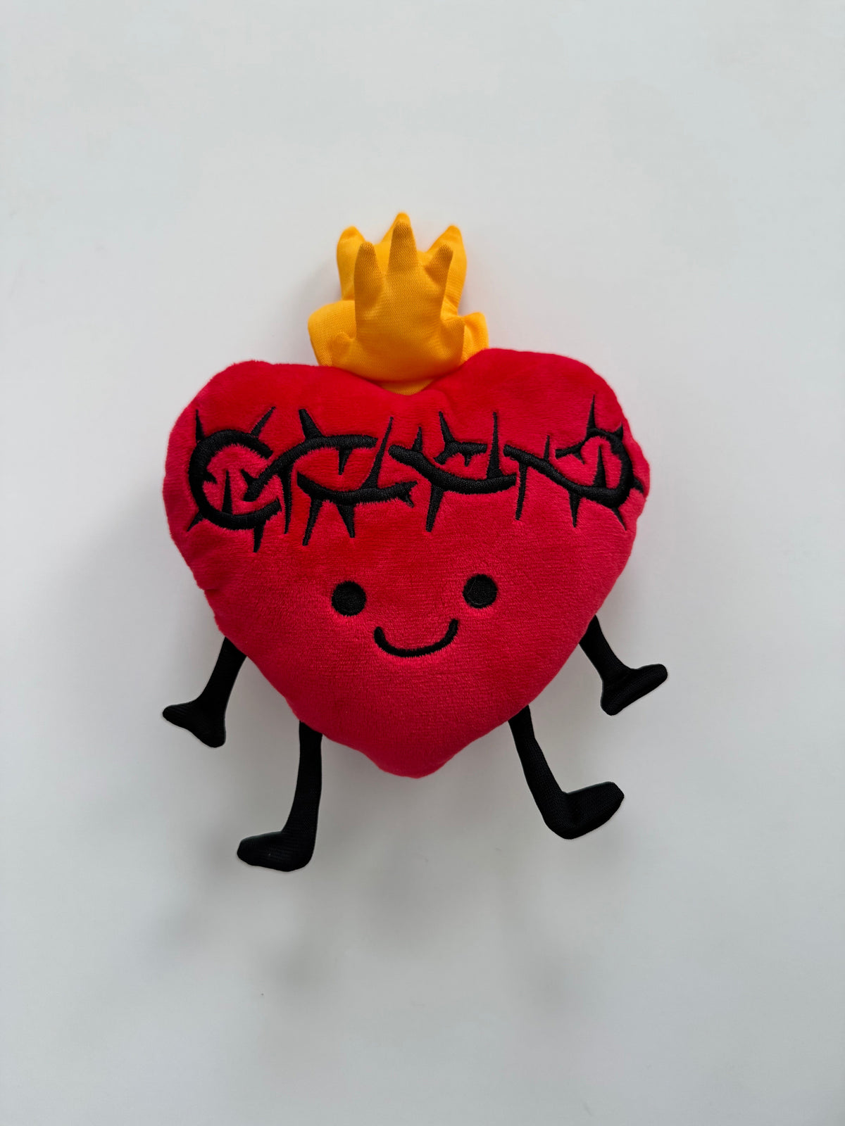 Sacred Heart plush toy with a joyful face and gentle flame, symbolizing love and comfort. Ideal for child’s bed or prayer shelf.