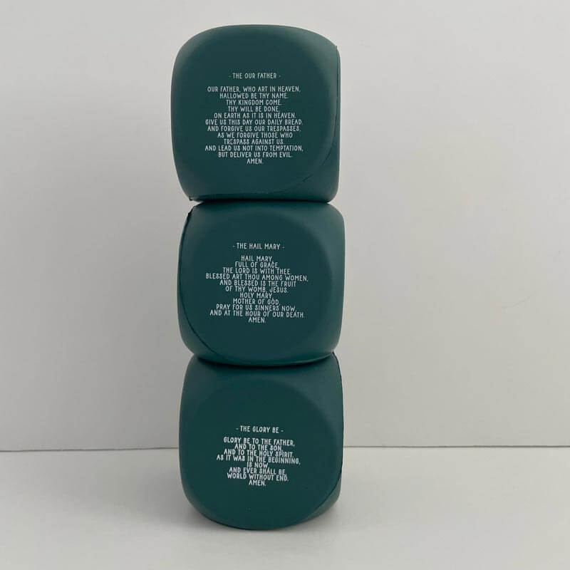 Three green Catholic prayer cubes stacked, featuring prayers like The Our Father, Hail Mary, and Glory Be printed on each side.